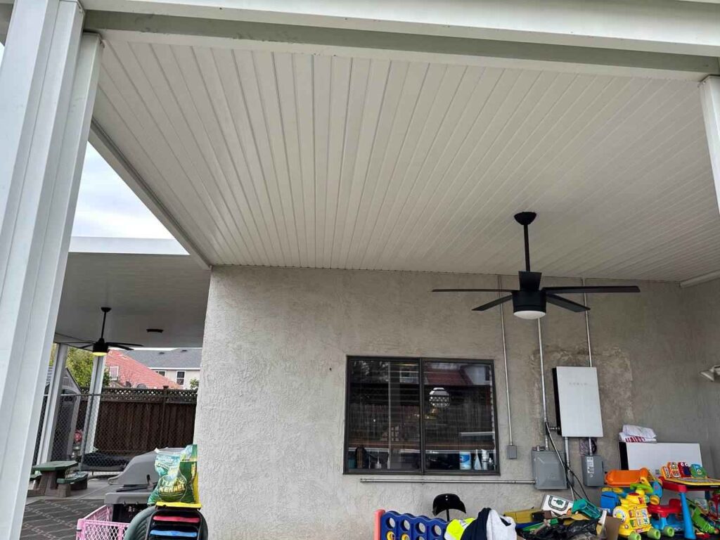 A Sacramento patio featuring a ceiling fan and a table, perfect for outdoor dining and relaxation
