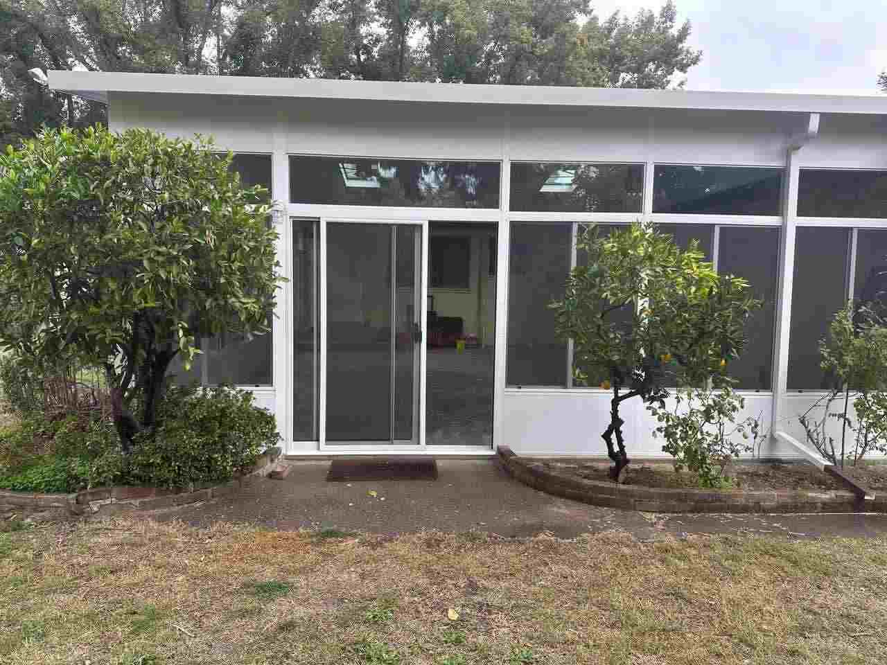 Single-Story Structure with Floor-to-Ceiling Windows Surrounded by Green Trees in Sacramento, CA